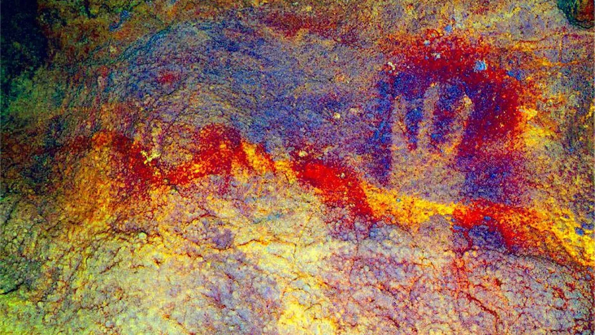 Red ochre hand stencils on a cave wall